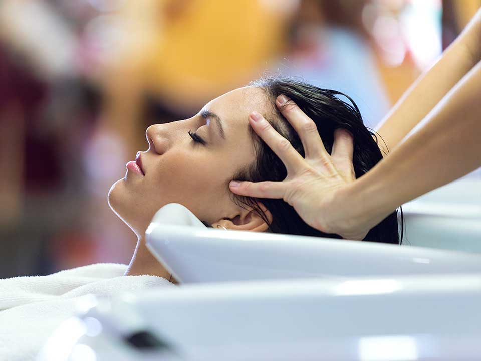 Femme brune bac coiffeur massage crânien tête